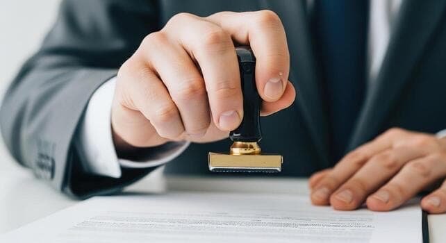 A notary applying an official seal to a signed document